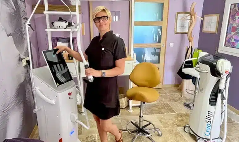 Machine minceur CryoSlim : soins esthétiques professionnels Praticienne en uniforme noir ajustant l'écran tactile d'une machine de traitement esthétique, avec un appareil CryoSlim visible à droite.